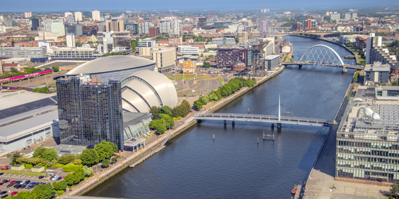 Aerial view of the River Clyde, with the Scottish Event Campus and glass tower of the Crowne Plaza hotel, with the city in the background