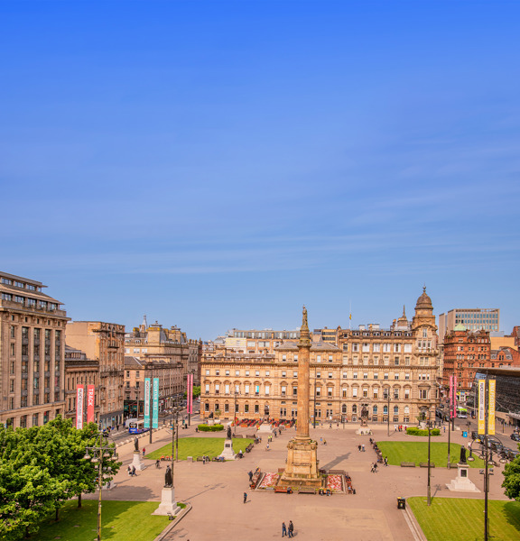 sunny view of George Square with a 24m column in the centre with a statue of Sir Walter Scott