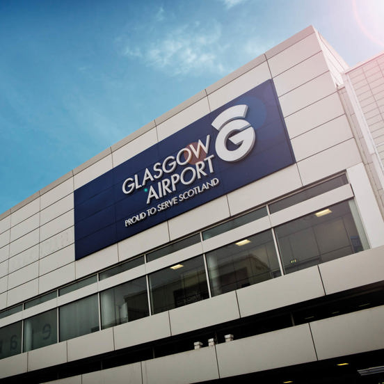 Modern square building with Glasgow Airport sign and logo