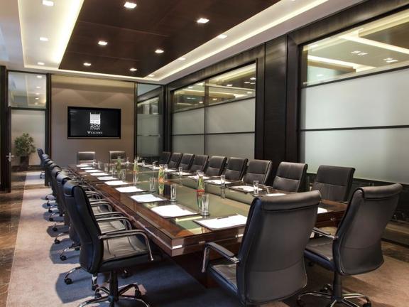 The Strathclyde suite set out in a boardroom configuration. The table is long and glass and the room has floor to ceiling windows on the main wall.